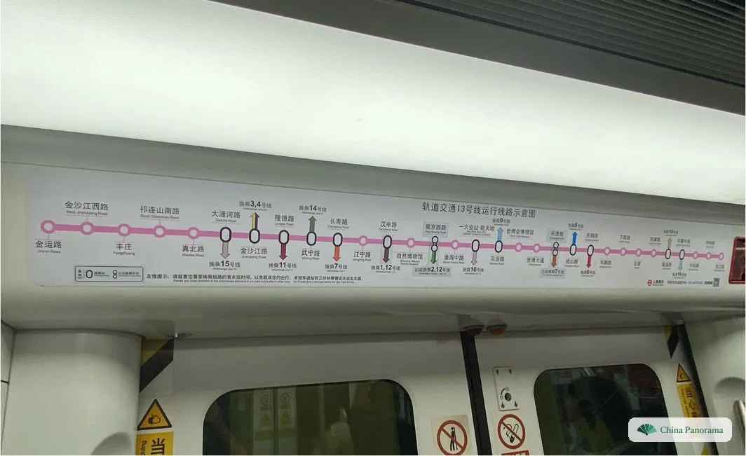 Line map of Shanghai Metro Line 13 above the door of a metro train, pink line with all stations and transfer notes