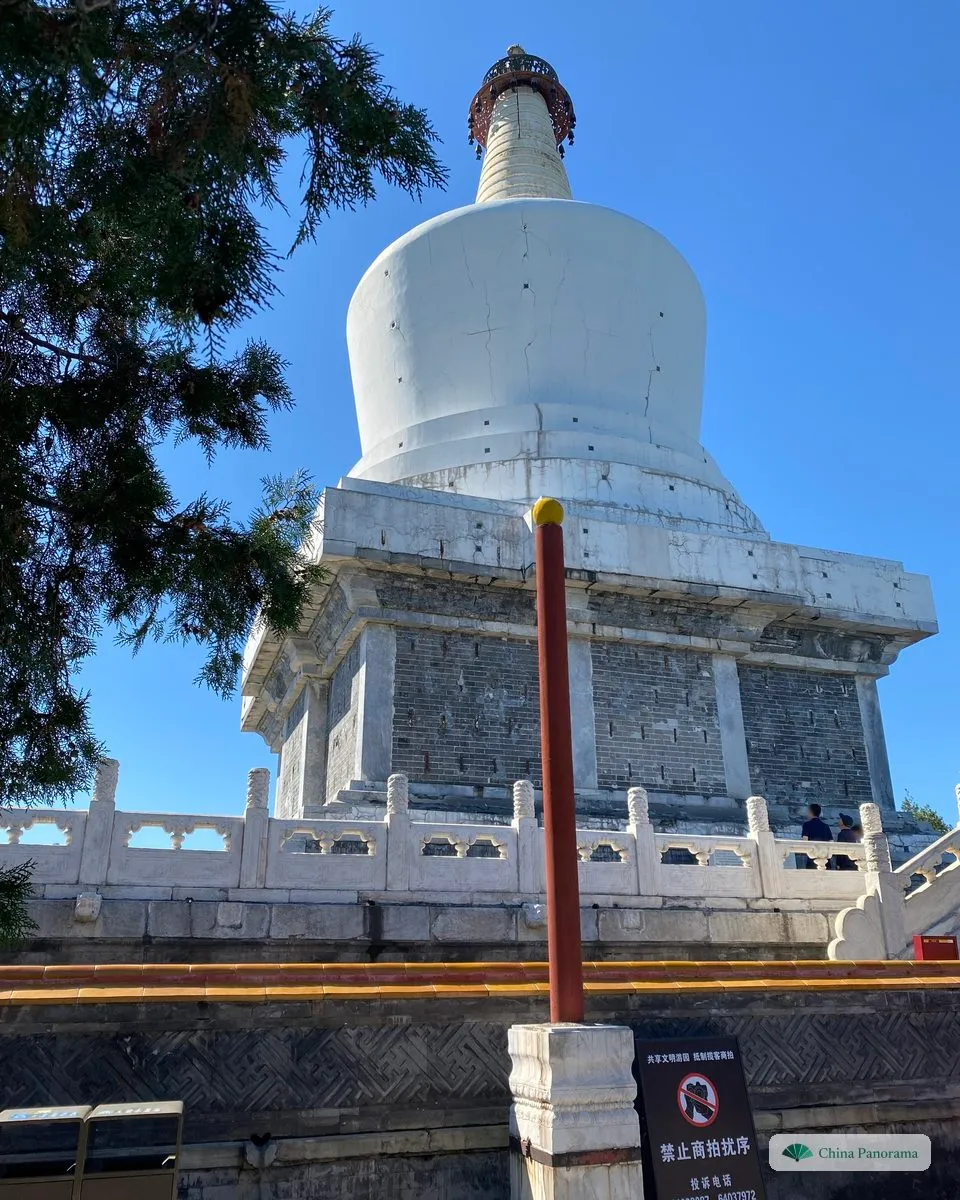 The White Dagoba in Beihai Park from below, a white bottle-shaped stupa on a stone base against a blue sky