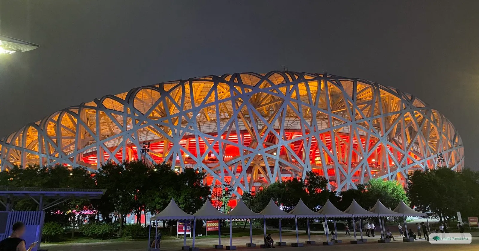 The National Stadium, the Bird’s Nest, lit red and gold from inside its lattice of steel at night