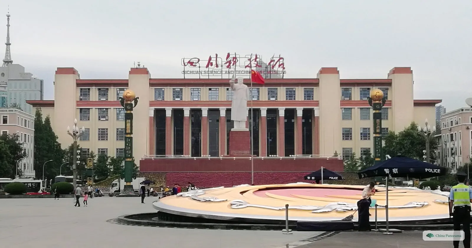 Tianfu Square: a white statue of Mao Zedong with raised hand in front of the cream-and-red Sichuan Science and Technology Museum, a round fountain with a sun-and-bird pattern in the foreground