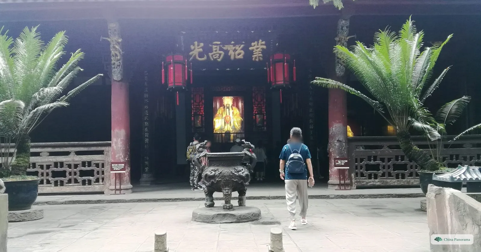The dark hall of Liu Bei with the gold plaque 業紹高光, a gilded seated statue inside, a bronze incense burner in front and cycads either side