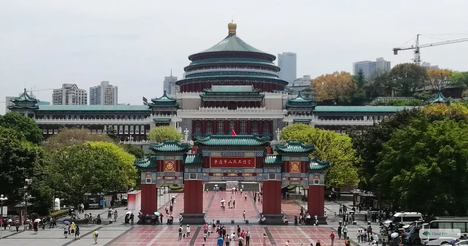 The Great Hall of the People in Chongqing: a round hall with a triple green-tiled roof on a long red-and-green palace, a red gateway in front and People’s Square below