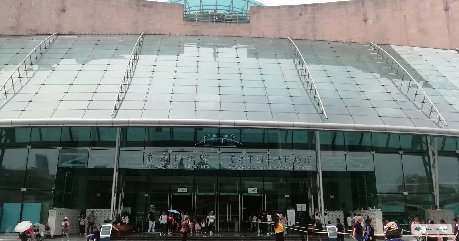 The glass front of the Three Gorges Museum under a curved, ribbed glass canopy, with a queue of visitors at the doors