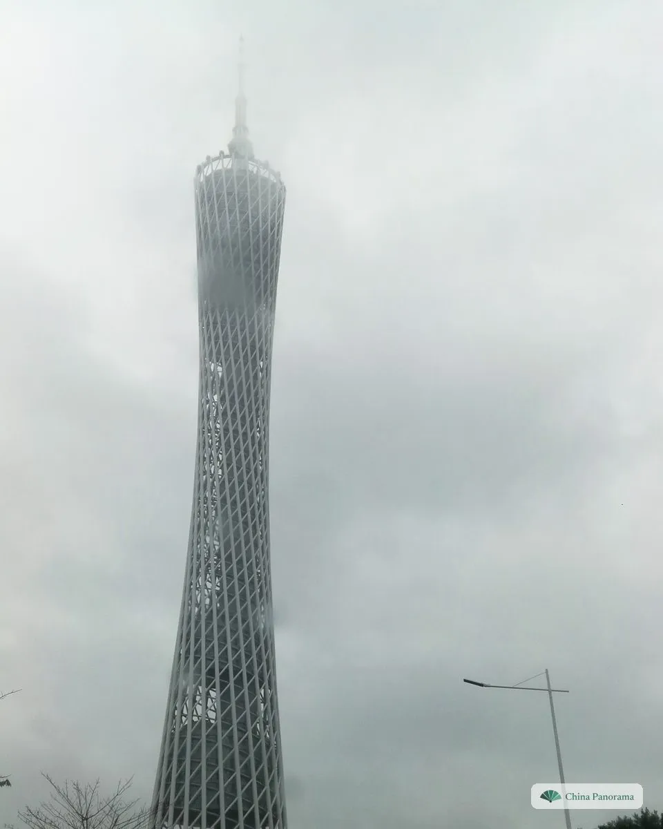 The Canton Tower in rain and mist, its upper part fading into low cloud