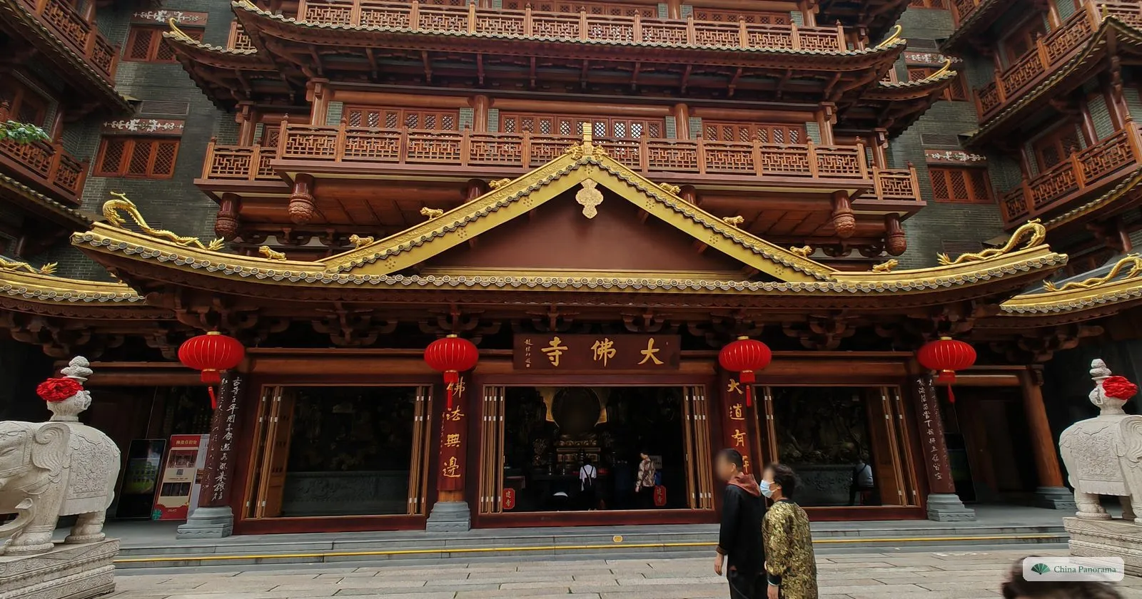 The red and gold main hall of Dafo Temple with the plaque 大佛寺, red lanterns along the eaves and white stone elephants at the steps