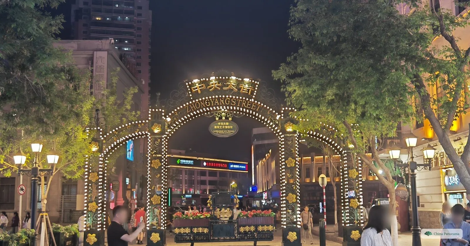 The illuminated Zhongyang Street gateway arch at the entrance to Central Street in Harbin at night