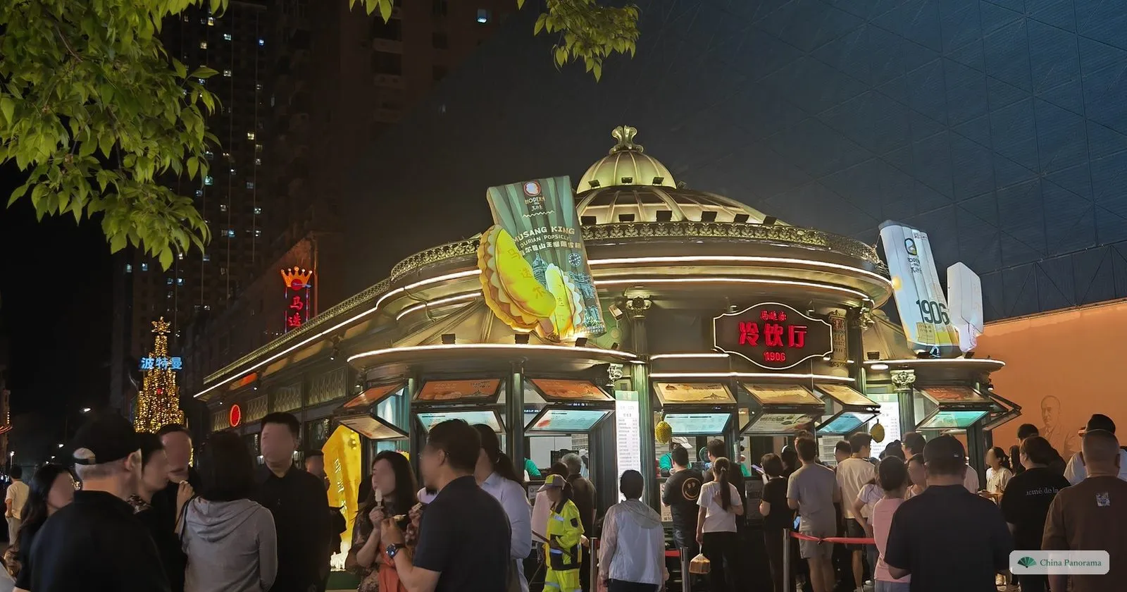 The domed Modern (Madieer) ice cream kiosk on Central Street in Harbin at night, with a queue around it