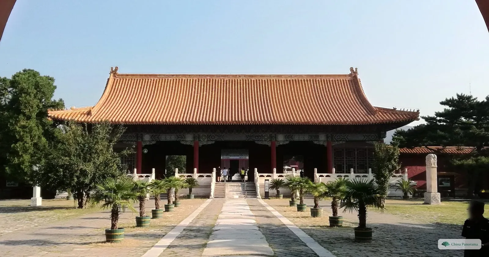 The Hall of Eminent Favour at Changling, a wide timber hall with a double yellow roof on a marble terrace, with potted palms along the path
