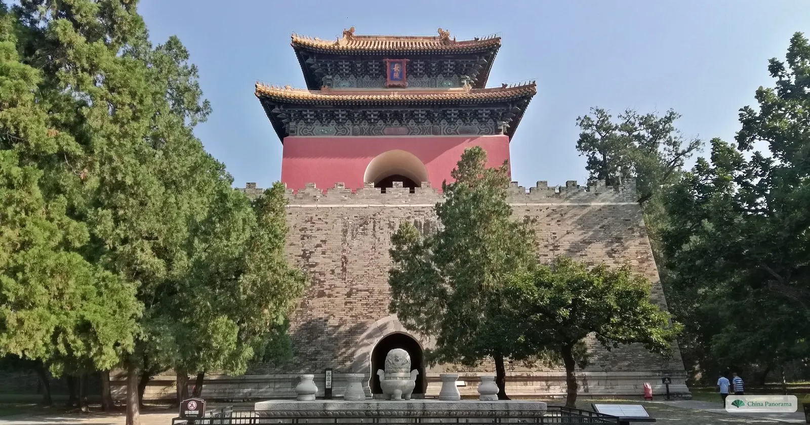 The soul tower of Changling, a red tower with a double roof on a high stone base, among cypresses
