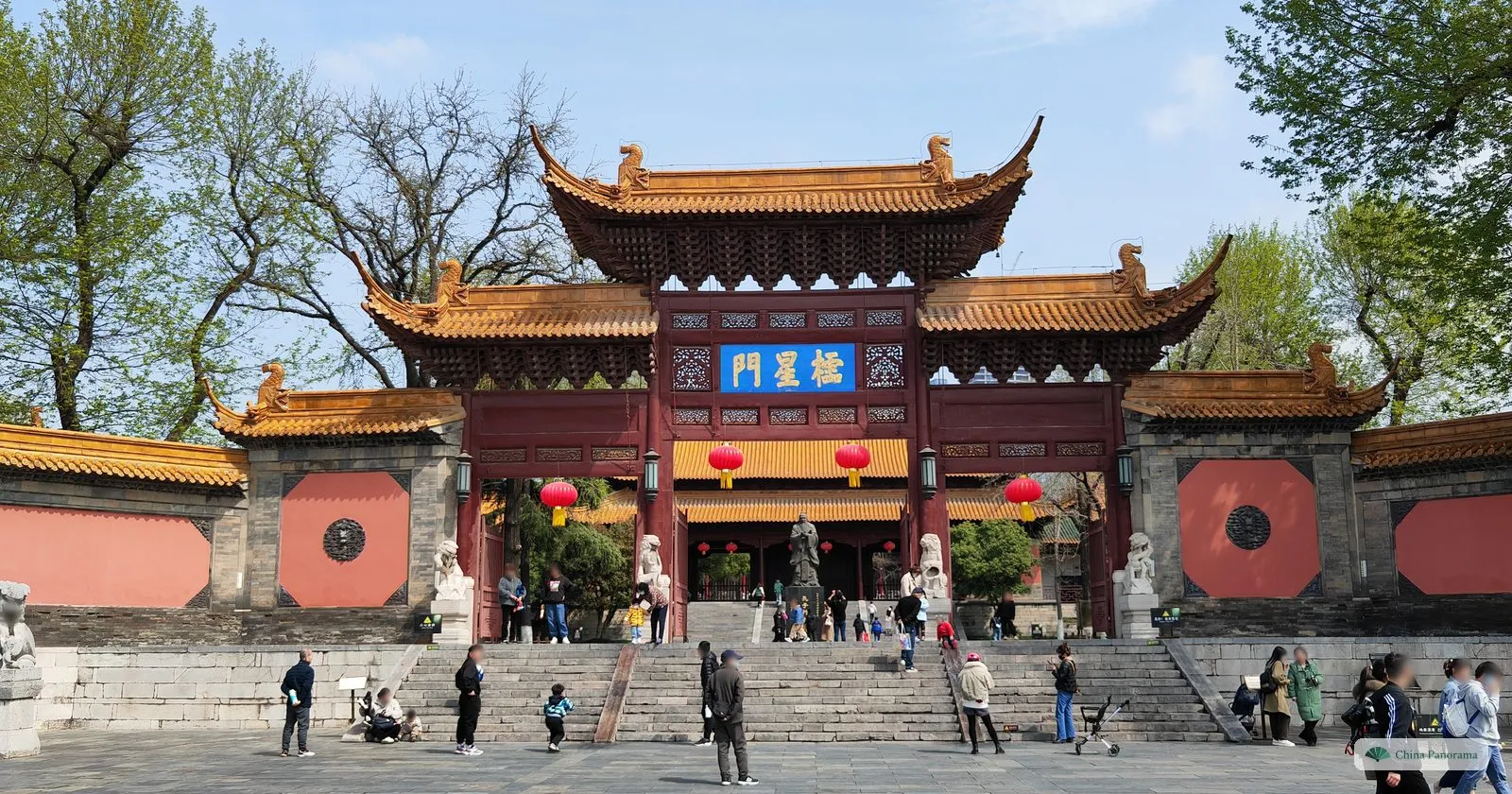 The red Lingxing Gate of Chaotian Palace with yellow tiled roofs and a blue plaque, stone lions and steps
