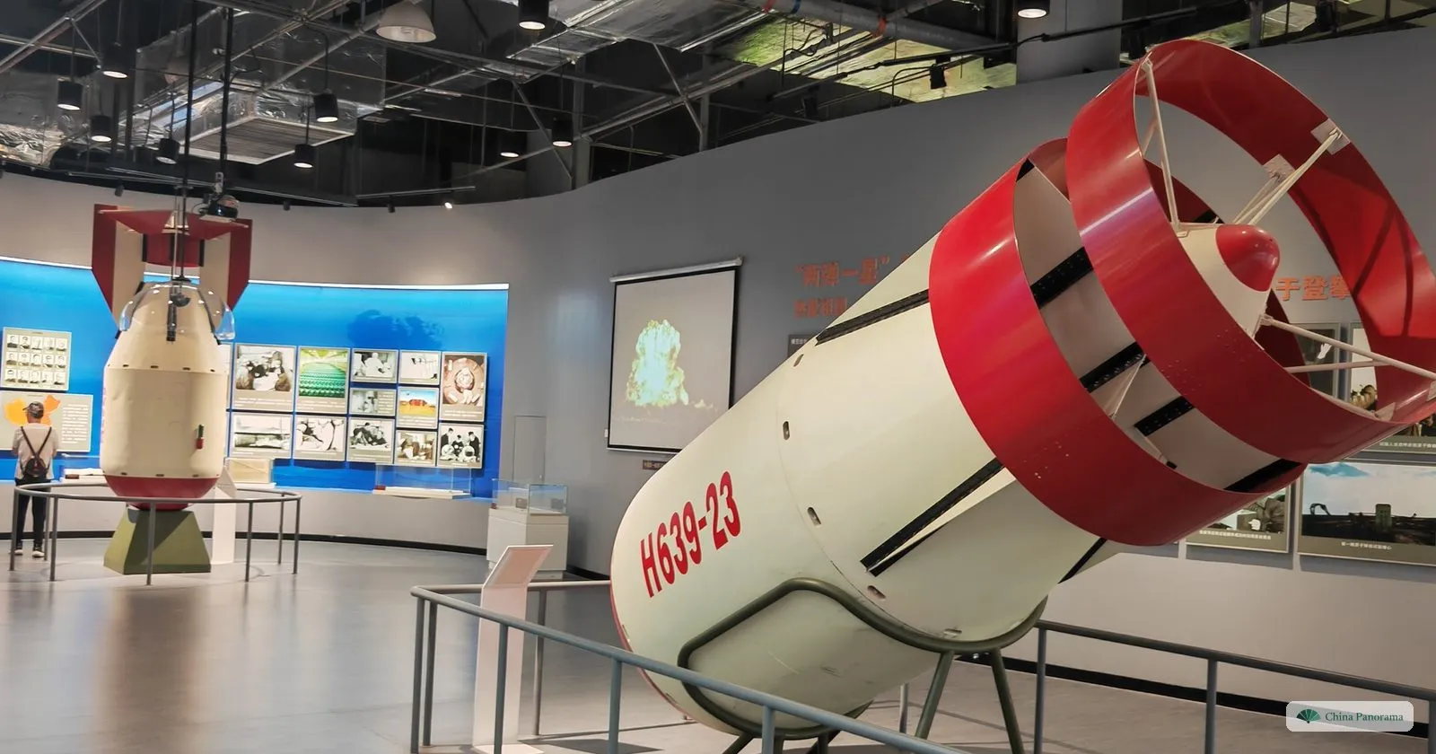 Full-size white and red casings of early Chinese nuclear weapons on stands in the China Nuclear Industry Science and Technology Museum