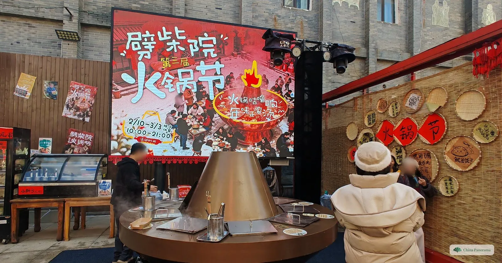 A hotpot festival stall in the Pichaiyuan food lanes in Qingdao, with a copper hotpot and a large red banner