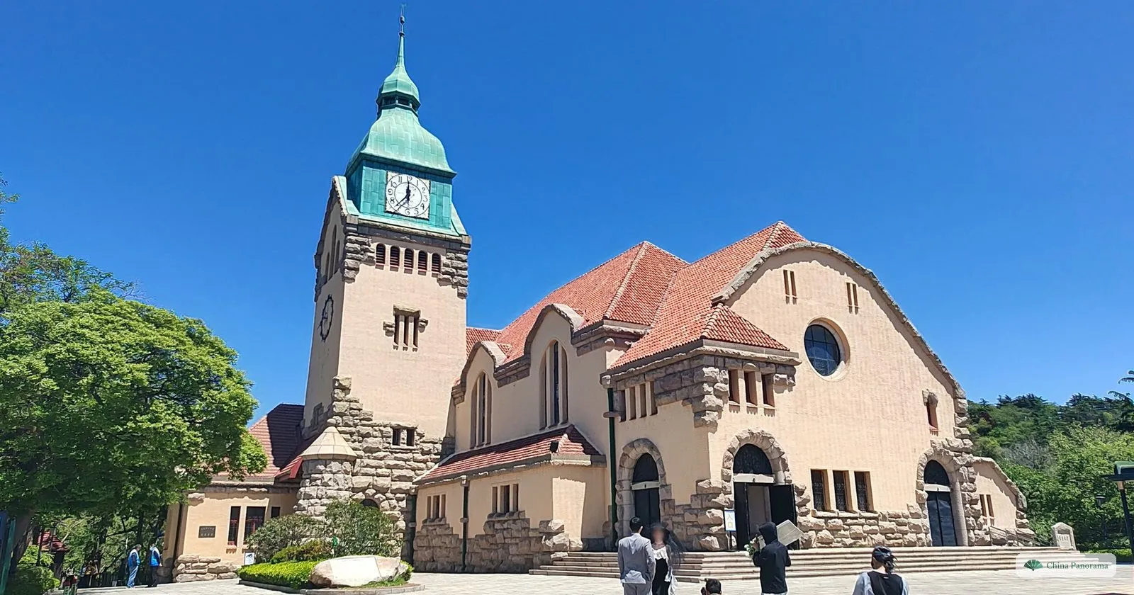 Qingdao Protestant Church, a 1910 German church with a green copper clock tower and a red roof, under a blue sky