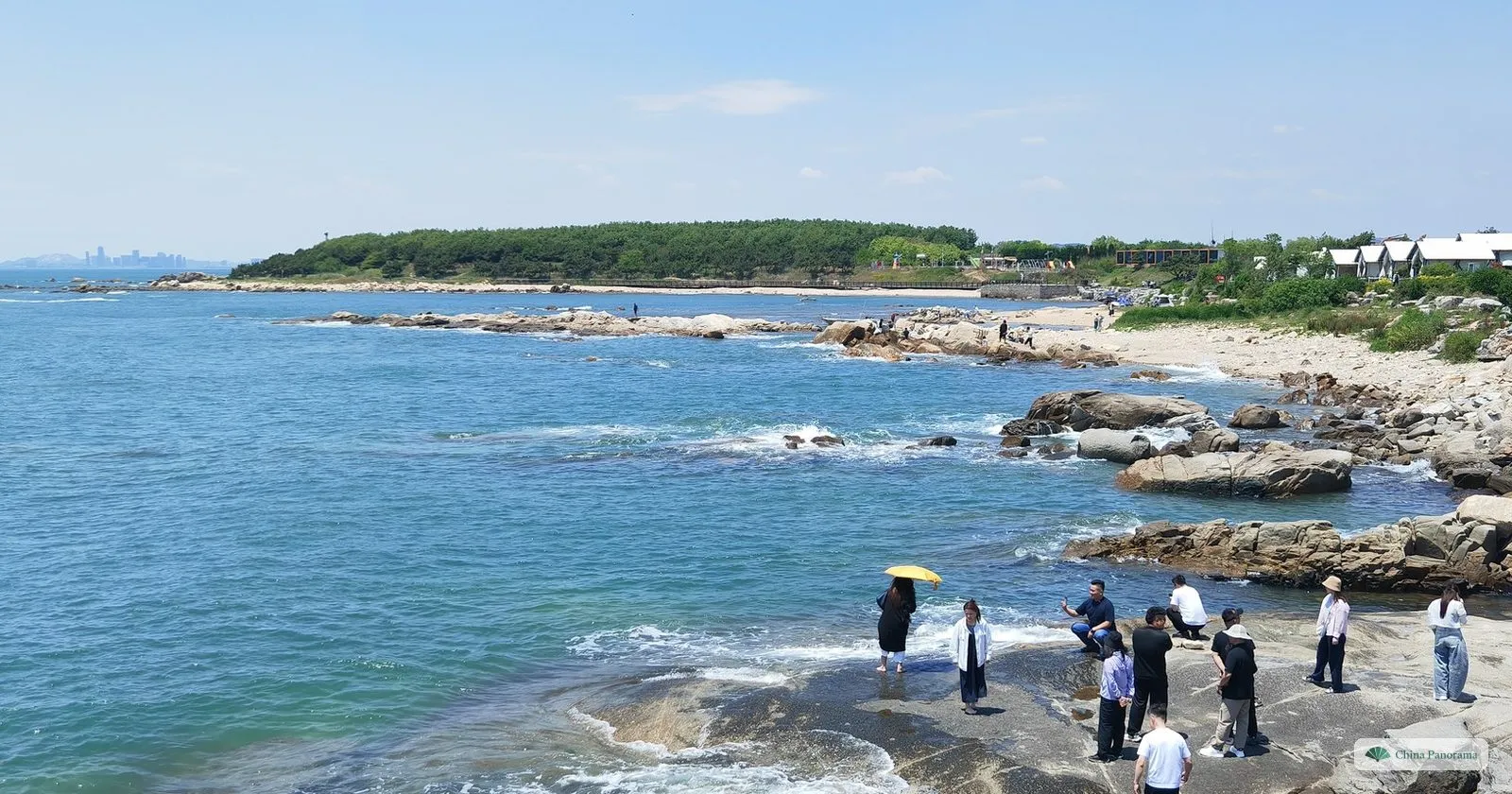 Visitors on the granite rocks at Yumingzui on Qingdao’s West Coast, with clear blue water