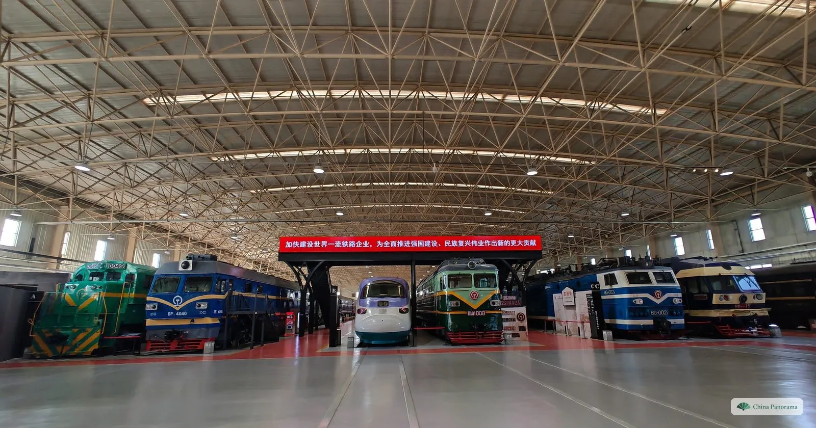 The locomotive hall of the China Railway Museum: a row of diesel, electric and high-speed trains under a wide steel roof