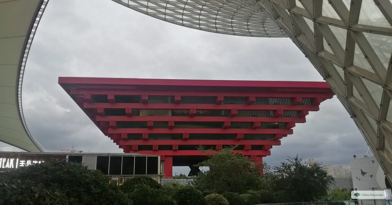 The red China Pavilion seen from under the white membrane roof of the Expo Axis