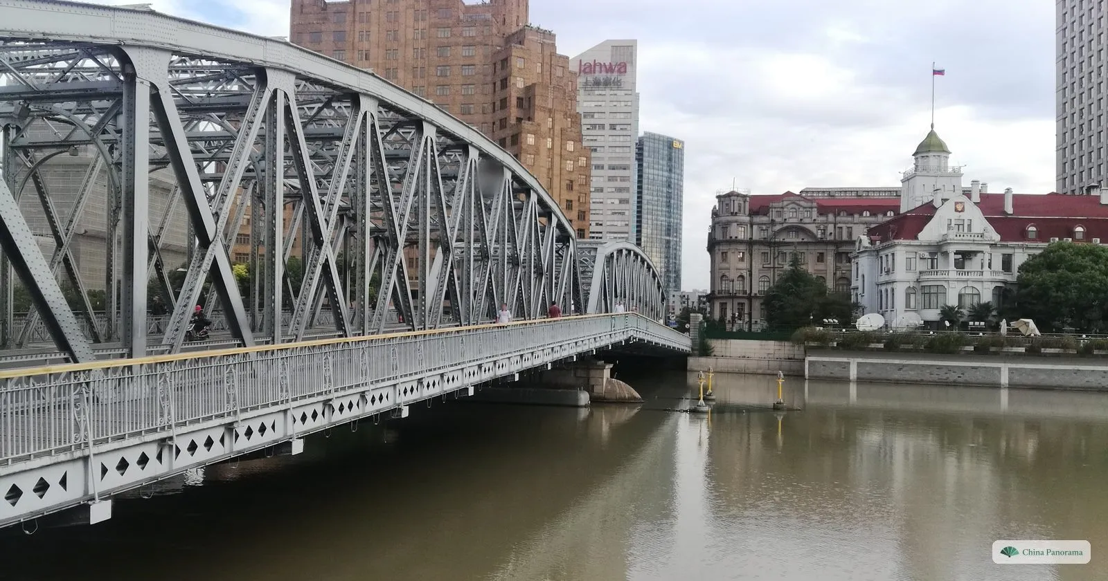 The steel truss of the Garden Bridge over Suzhou Creek, with the brown-brick Broadway Mansions and the white, red-roofed Russian consulate on the far bank