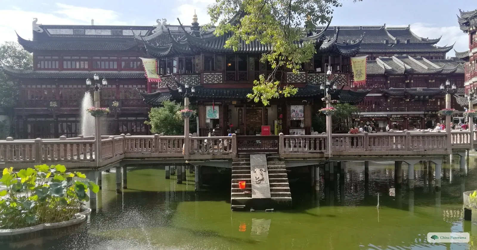 The Huxinting teahouse seen across its pond, with a fountain and lotus leaves in front