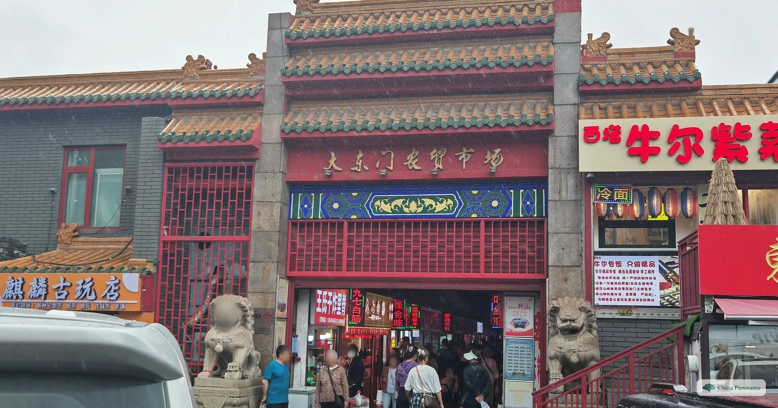 The red and green entrance of the Dadongmen farmers’ market in Shenyang, flanked by two stone lions