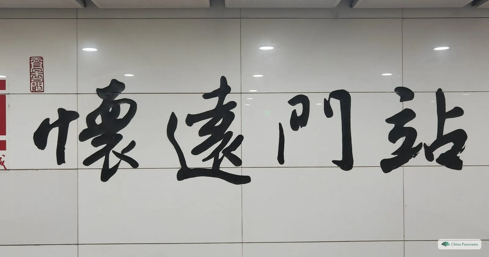 The station name Huaiyuanmen written in large black calligraphy on the white wall of the metro station