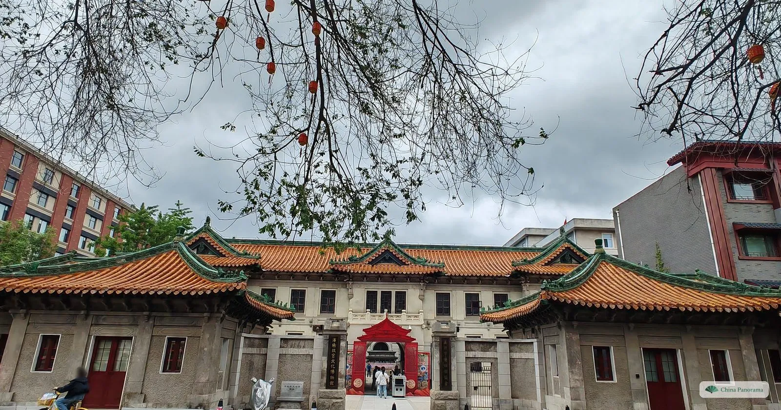 A long building with glazed orange-tiled roofs and a pale European-style centre on Chaoyang Street in Shenyang, with a red gate in the middle