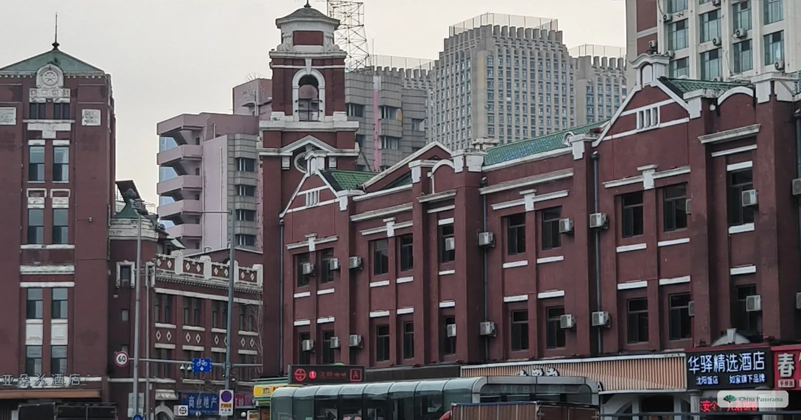 Red-brick railway-era buildings with a small tower on the square in front of Shenyang Railway Station