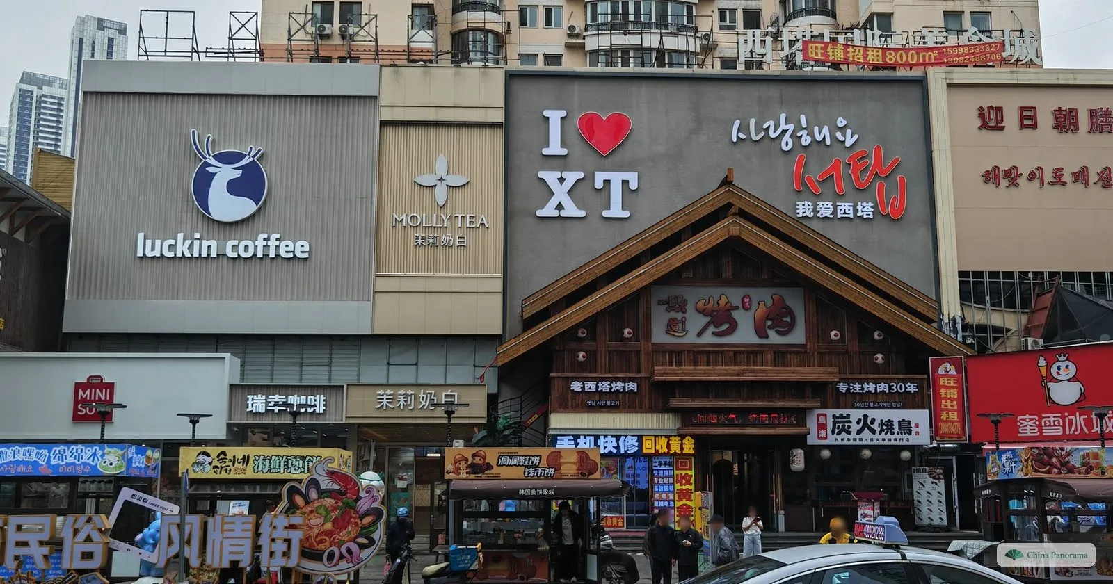 Shop fronts in Xita, Shenyang, with signs in Korean and Chinese and a wooden-fronted barbecue restaurant
