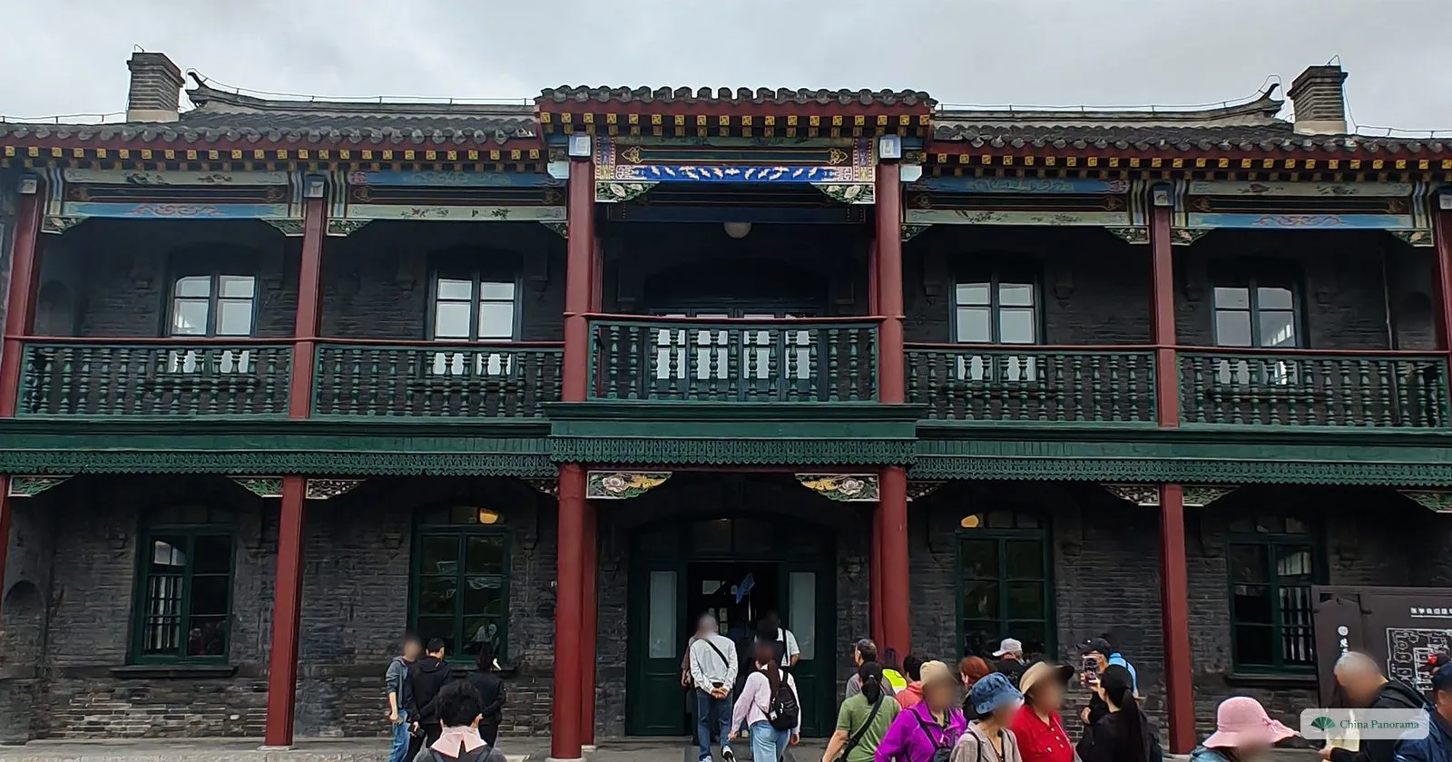 The two-storey Small Green Building at Zhang’s Mansion, with red columns and green balconies, and a queue of visitors