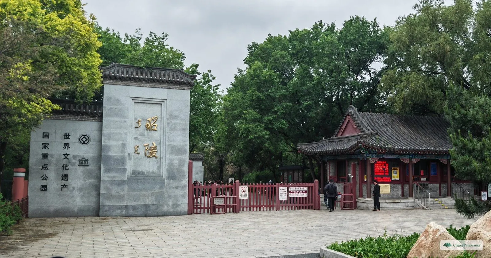 A grey stone wall at a gate of Beiling Park carved with the name Zhaoling, “World Cultural Heritage” and the UNESCO emblem, beside a traditional ticket pavilion