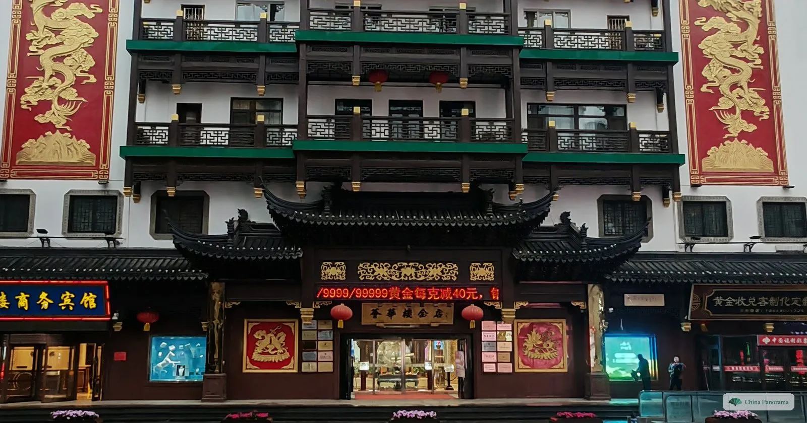 The ornate multi-storey front of the Cuihua jeweller on Zhongjie in Shenyang, with red dragon banners