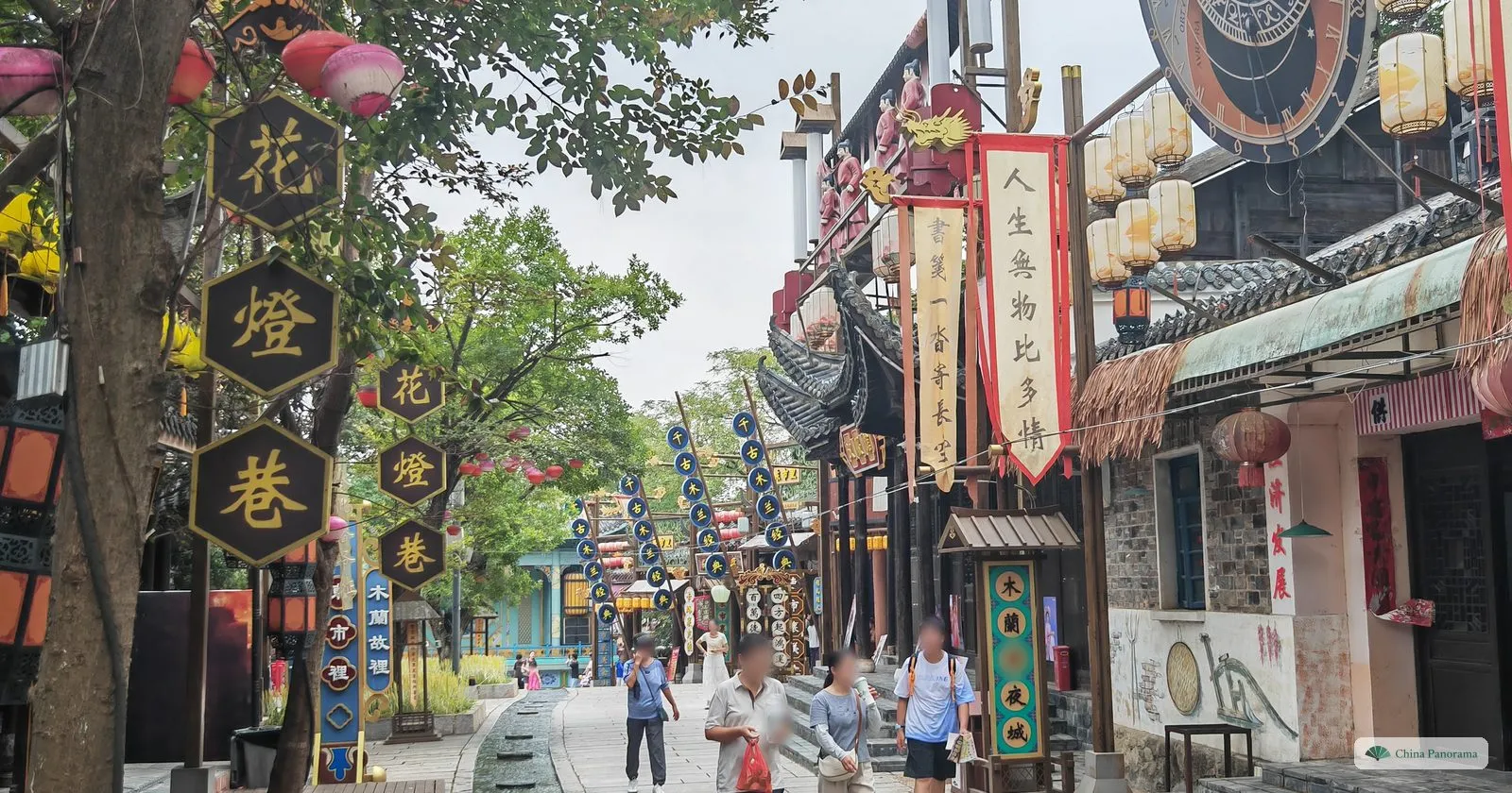 A lane of wooden shops with hexagonal signs 花燈巷, banners and lanterns, visitors walking