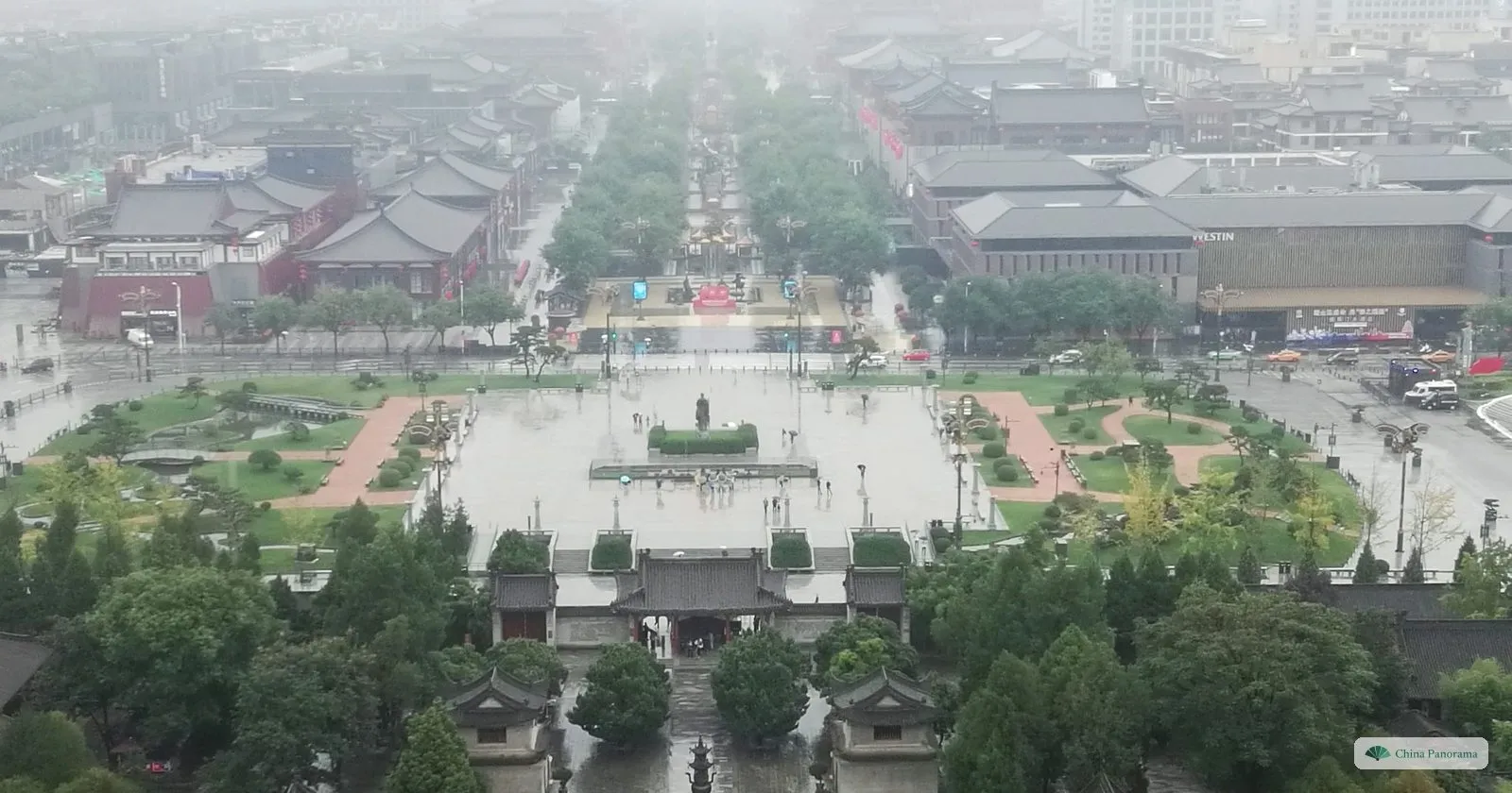 View south from the Giant Wild Goose Pagoda in the rain: the temple gate below, the South Square with the statue of Xuanzang in the middle, and the tree-lined start of Grand Tang Mall beyond