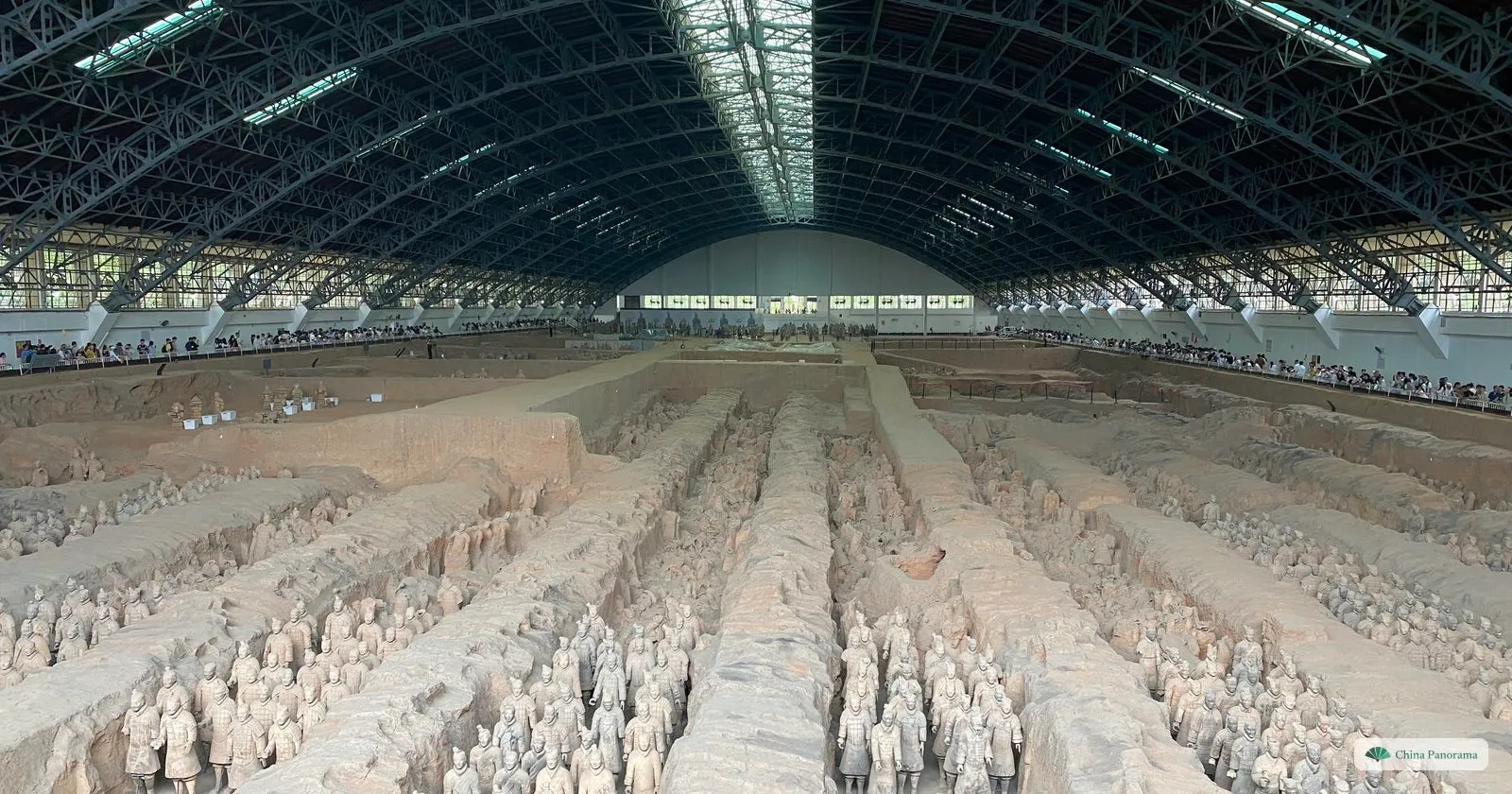 Columns of terracotta soldiers four abreast in the corridors of Pit 1, with the far end of the hall and the visitor galleries in the distance